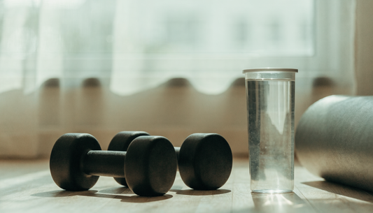 Bright minimalist home gym with dumbbells and a water bottle in soft daylight