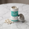 Collagen Beauty capsules beside the open pot on marble