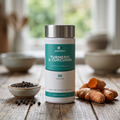 Turmeric & Curcumin pot on a wooden table with fresh turmeric root and peppercorns